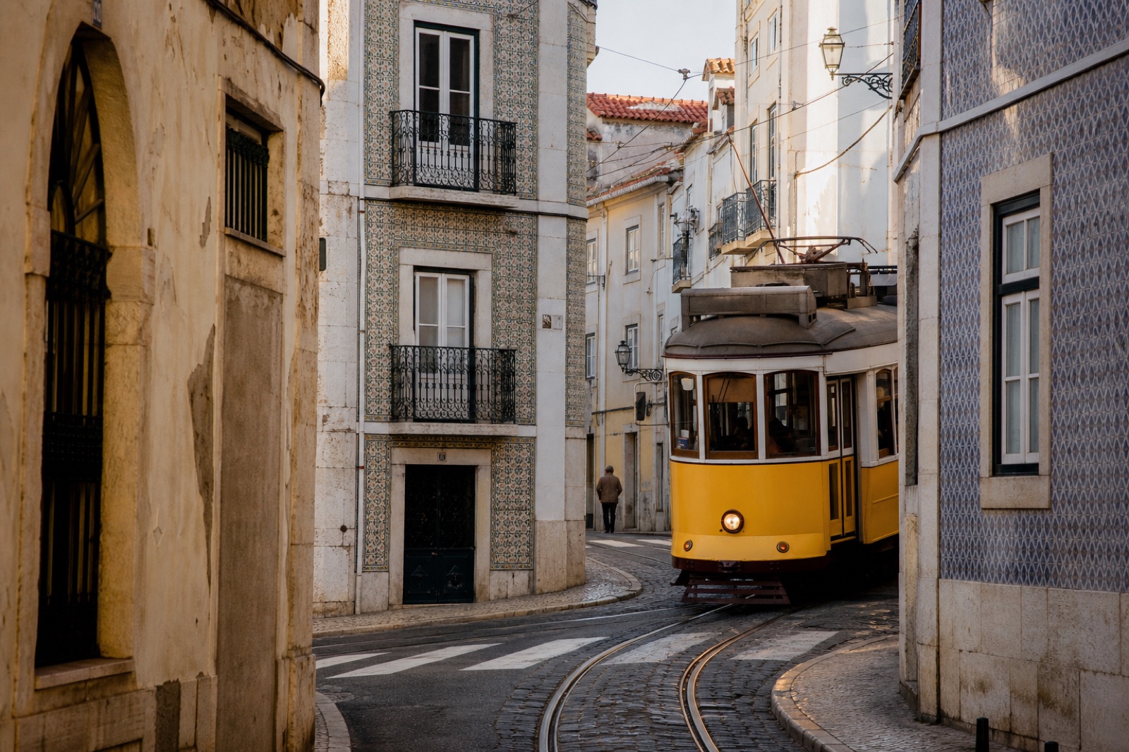 A yellow tram moving through a tiled Lisbon street.